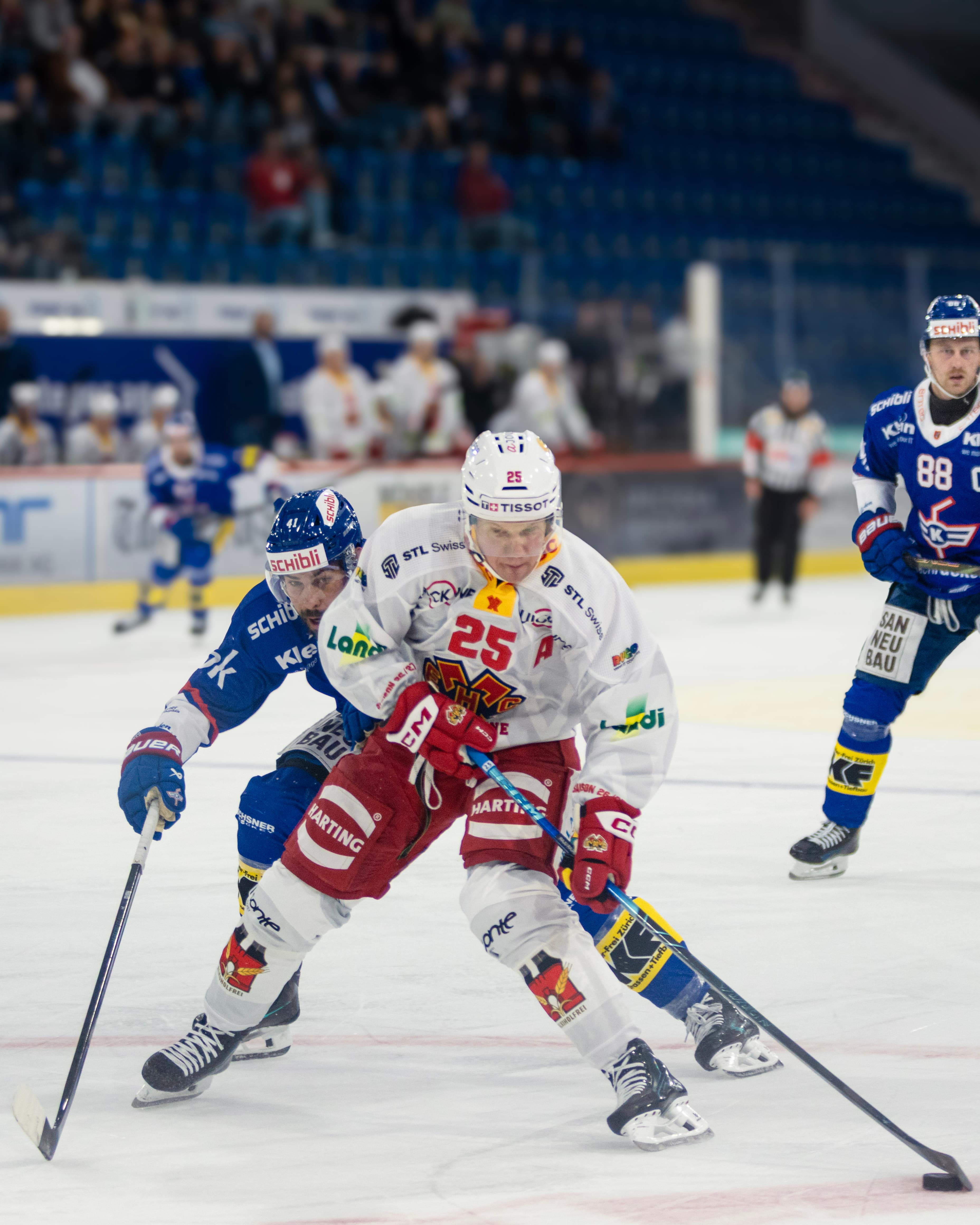 Biel-Spieler Nummer 25 im Laufduell mit zwei Kloten-Spielern